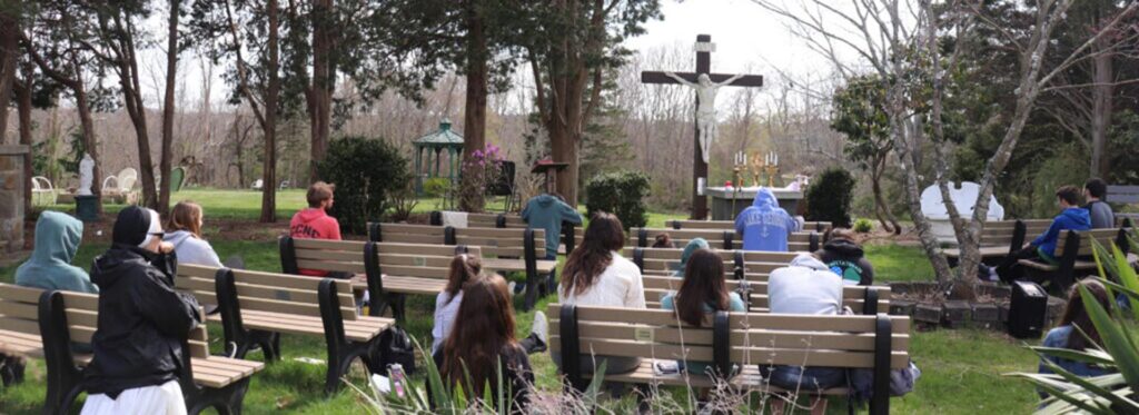Students in prayer at outdoor chapel