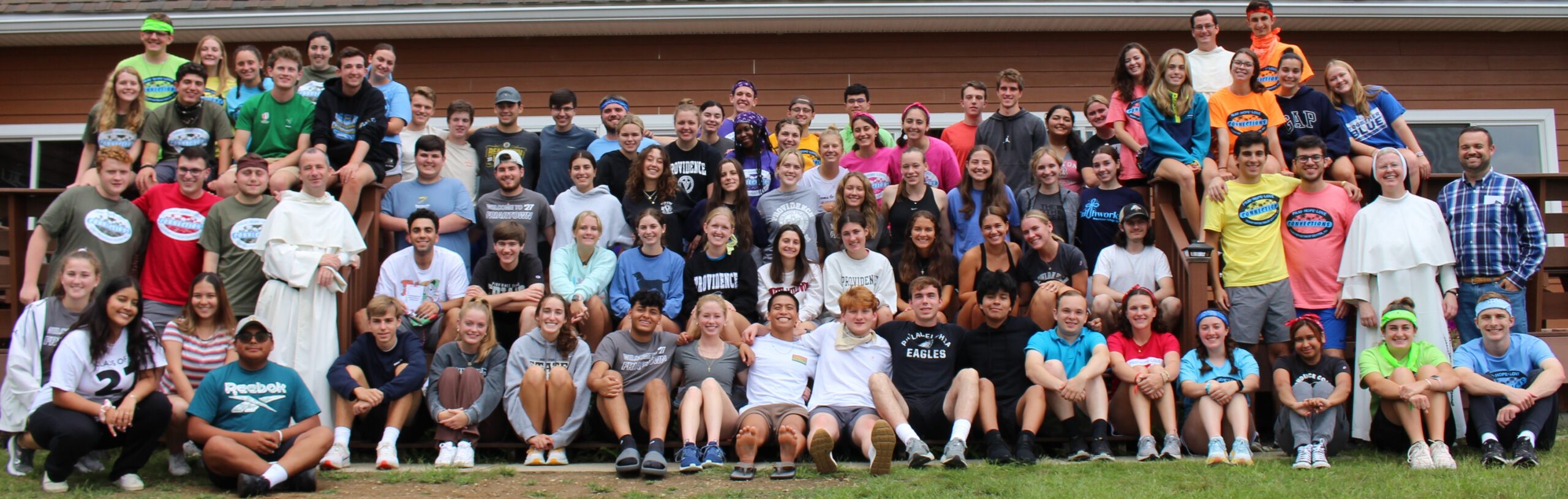 A group of students in front of a wooden wall