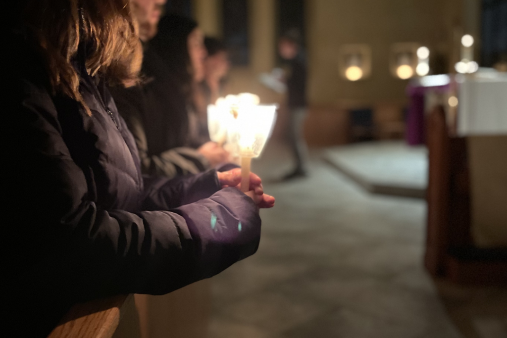 A student holds a candle at a prayer vigil