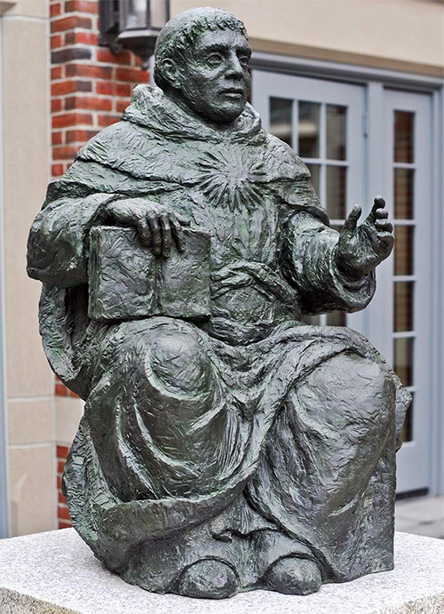 Statue of St. Thomas Aquinas outside of the Phillips Memorial Library on campus