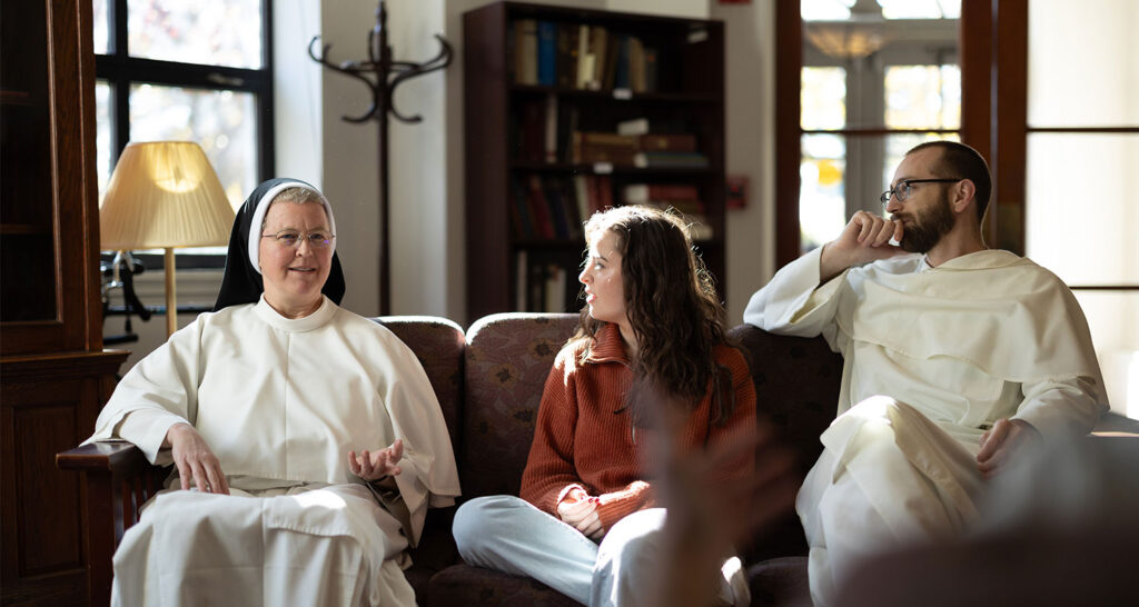 two dominicans and a student sitting on a couch