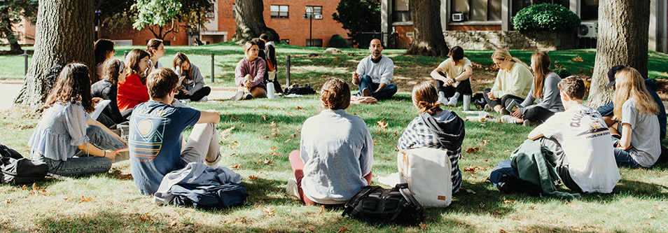 Students outside on a fall day talking with each other